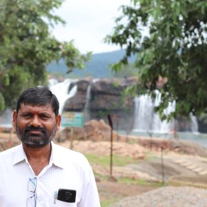 indian uncle standing in front of bogata waterfall